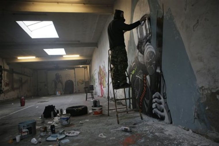 In this photo taken Wednesday Sept. 29, 2010, a squatter paints a mural in a former fire department building in Amsterdam, Netherlands. The once-respected Dutch tradition of squatting becomes illegal on Friday, Oct. 1, 2010. In Amsterdam, the epicenter of the movement known in Dutch as \"kraken,\" or \"breaking,\" squatters plan a demonstration Friday against the new law that makes their way of life punishable by up to one year in prison. (AP Photo/Peter Dejong)